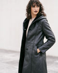 Manteau long en peau lainée noire, élégant et sophistiqué