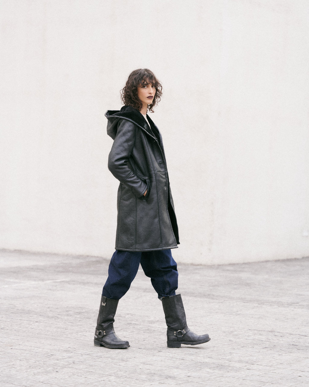 Manteau long en peau lainée noire, élégant et sophistiqué