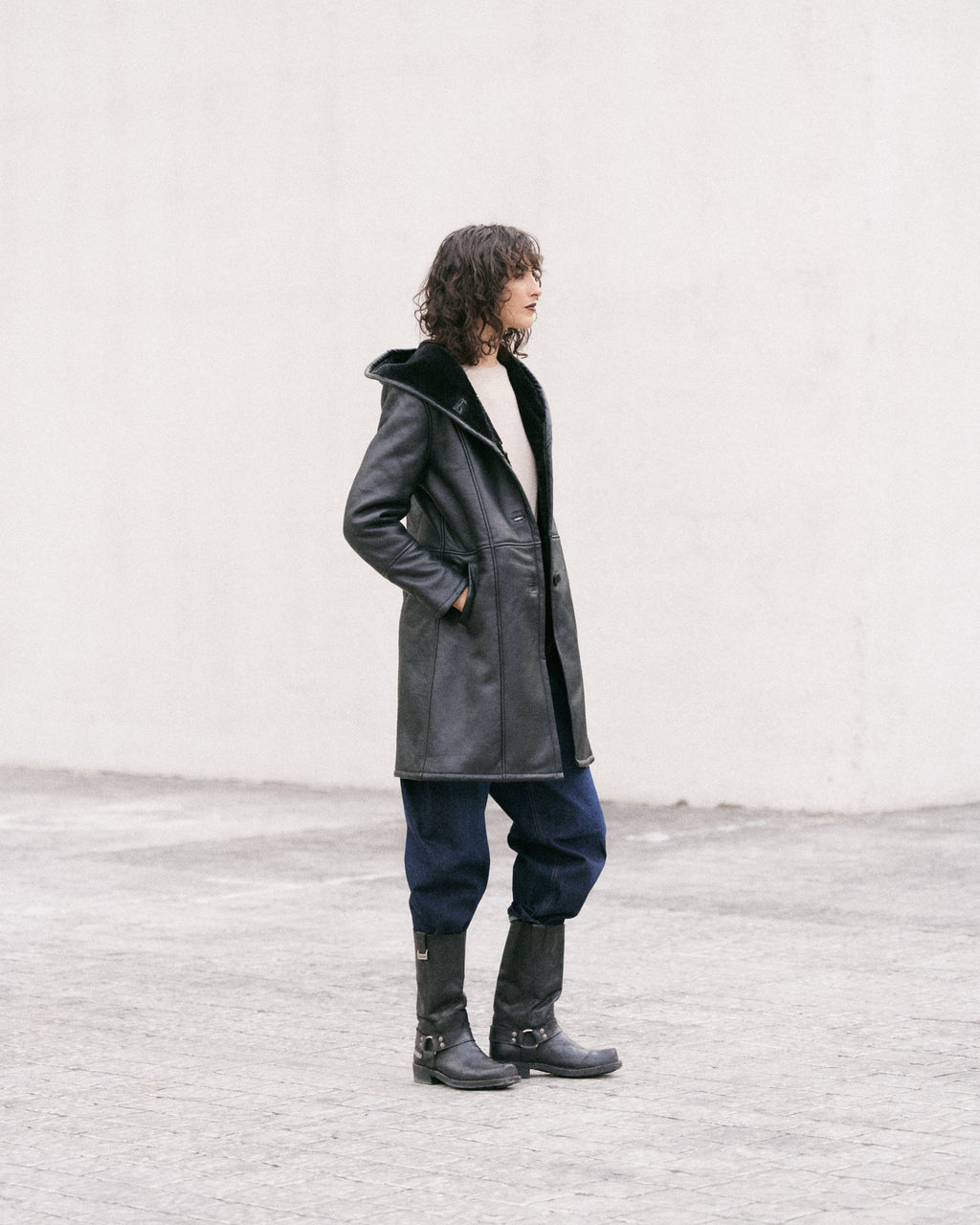 Manteau long en peau lainée noire, élégant et sophistiqué