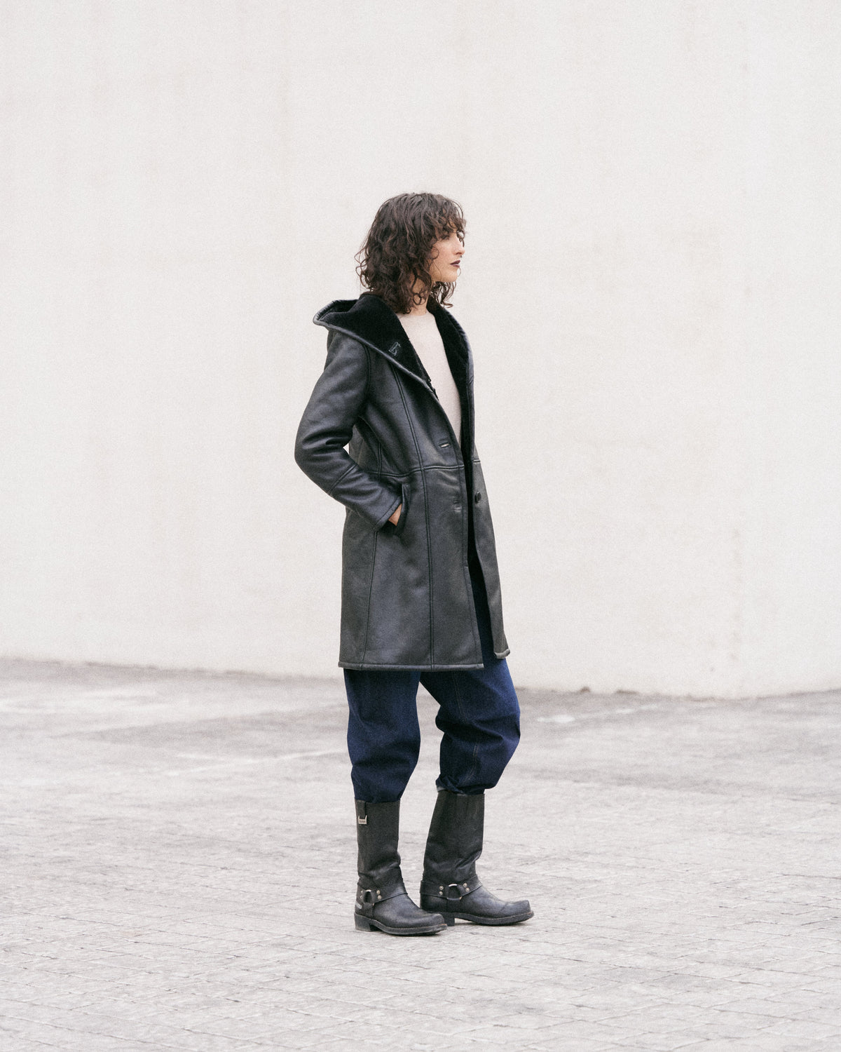Manteau long en peau lainée noire, élégant et sophistiqué