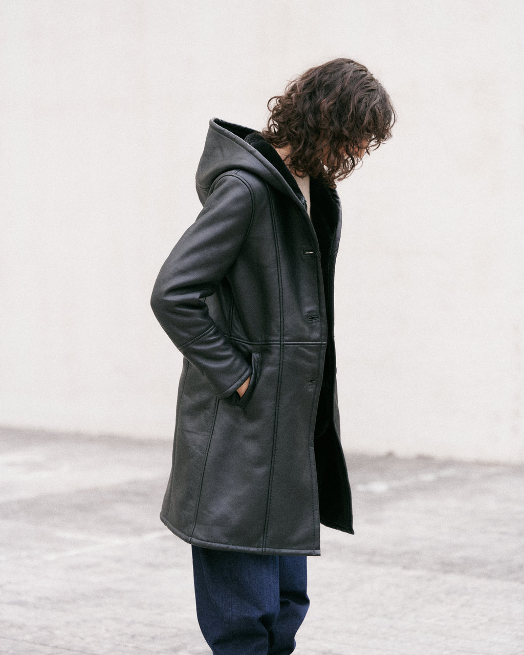 Manteau long en peau lainée noire, élégant et sophistiqué