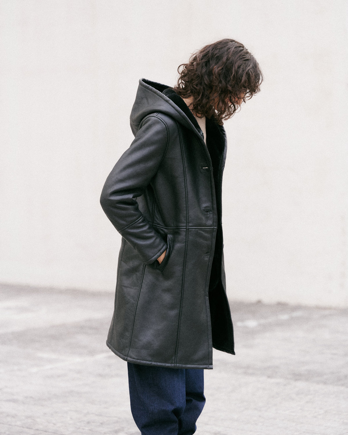 Manteau long en peau lainée noire, élégant et sophistiqué