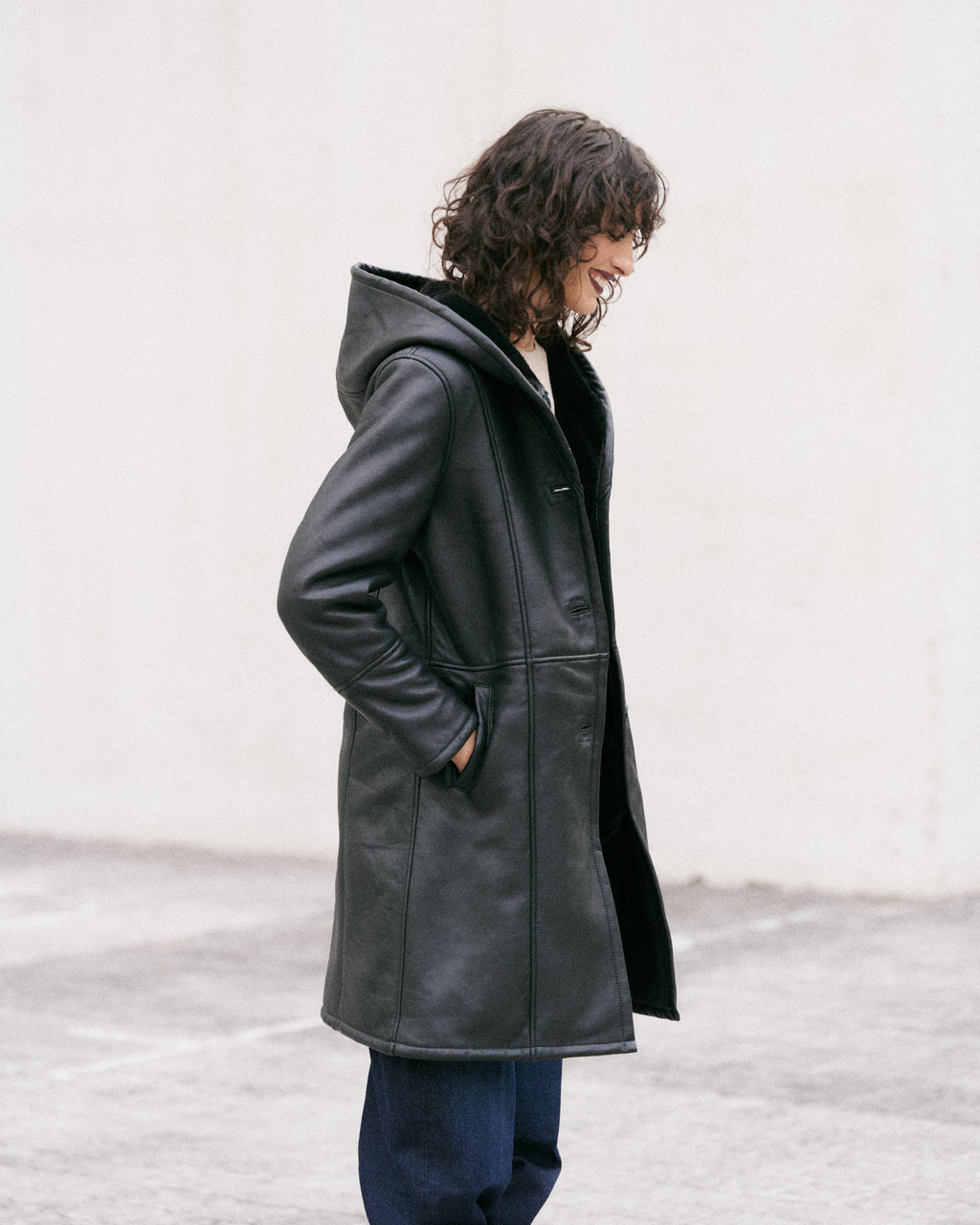 Manteau long en peau lainée noire, élégant et sophistiqué
