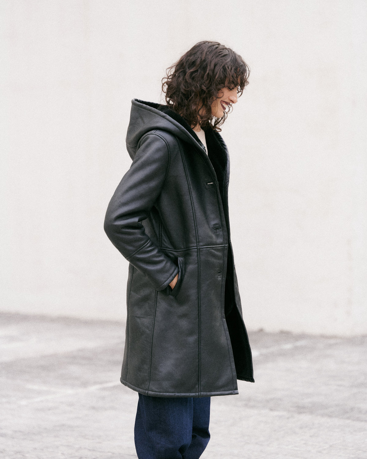 Manteau long en peau lainée noire, élégant et sophistiqué