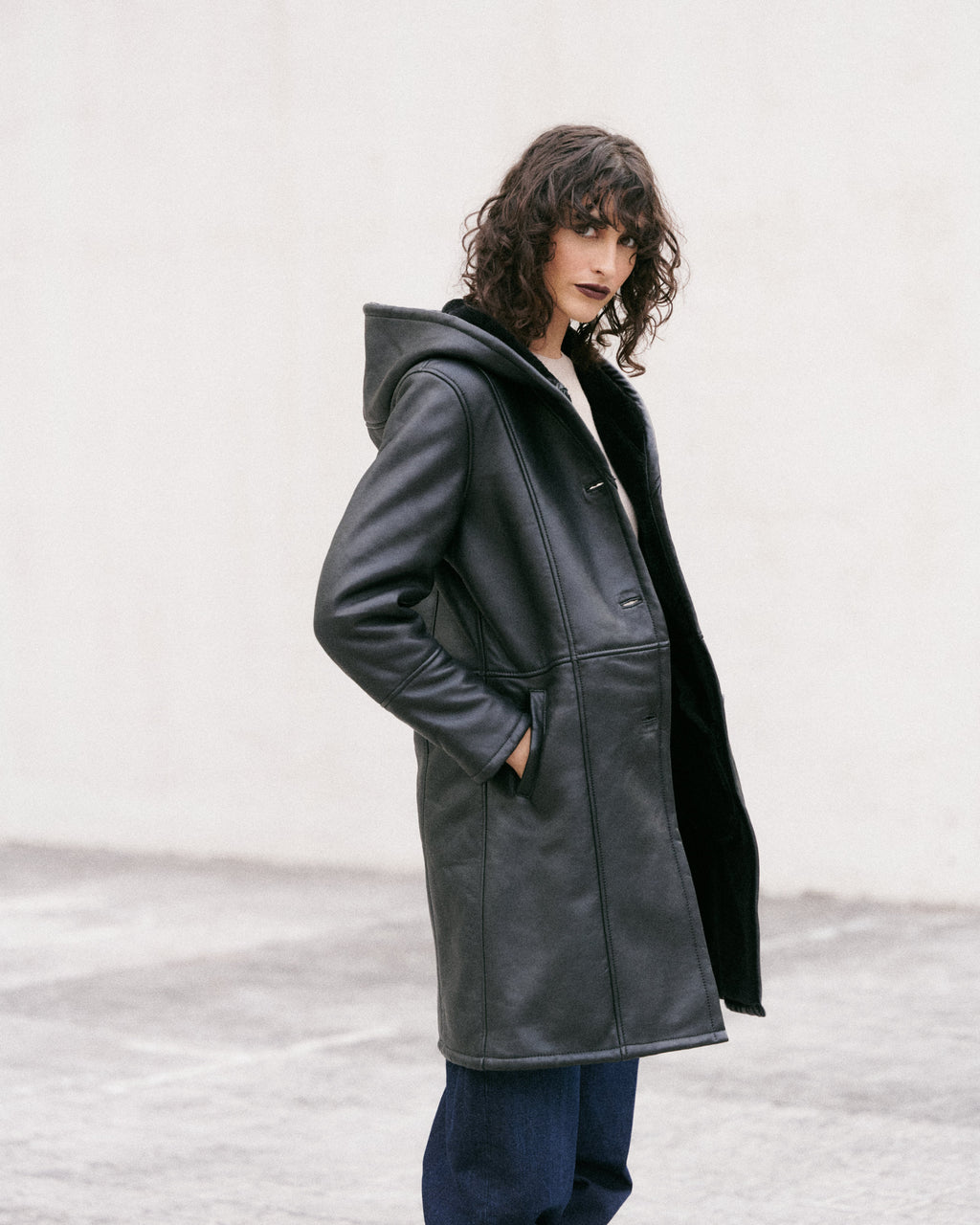 Manteau long en peau lainée noire, élégant et sophistiqué